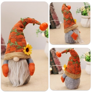 Detail of harvest gnome doll with orange knit hat, sunflower, and pumpkin bell decoration