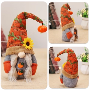Detailed view of autumn gnome with knitted hat, sunflower accent and small pumpkin decor