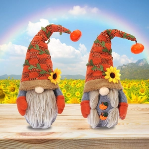Pair of Thanksgiving harvest gnomes with sunflowers and pumpkin accents on wood