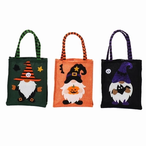 Three Halloween non-woven gnome gift bags with witch hats and colorful striped handles