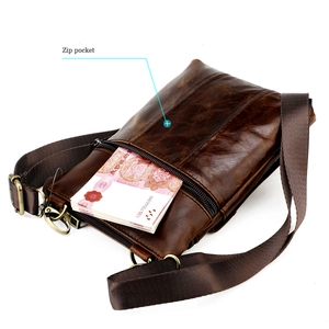 Detail of vintage brown leather messenger bag featuring a secure back zip pocket and strap