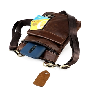 Macro view of genuine leather messenger bag with multiple zipper pockets and card slots