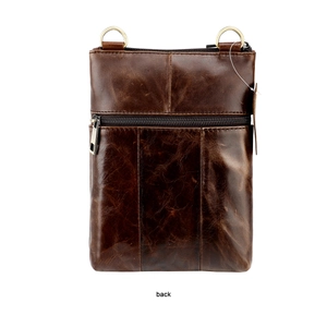 Detail of dark brown leather crossbody bag back with smooth zipper and vintage D-rings