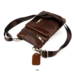 Side view detail of a premium brown cowhide leather bag with bronze zippers and strap