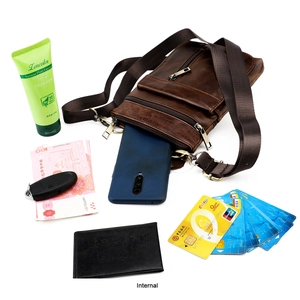 Internal storage detail of brown leather crossbody bag showing compartments for phone and cards