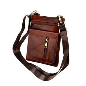 Side view of dark brown genuine leather messenger bag showing thick layers and brass zippers