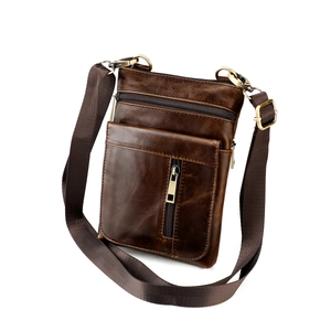 Macro shot of dark brown genuine leather messenger bag featuring retro texture and zippers