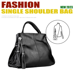 Detail of black pebbled leather tote bag featuring double tassel pendant and large capacity