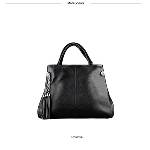 Detail of black lychee grain leather handbag with silver chain and long tassel pendant