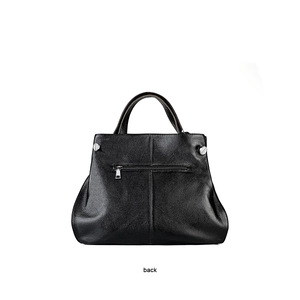 Detailed view of the back pocket on a black litchi grain leather handbag with silver hardware