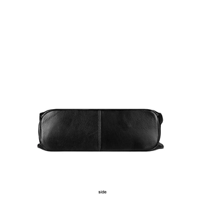 Side view detail of black lychee grain leather handbag showing high-quality stitching
