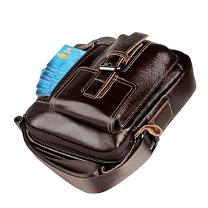Dettaglio della borsa a tracolla in pelle marrone scuro con più strati di cerniere e texture