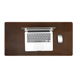 Vista superior de un tapete de escritorio de cuero marrón con costuras bajo la laptop