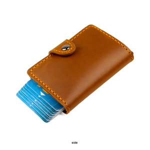 Detail of brown crazy horse leather wallet with orange stitching and silver button