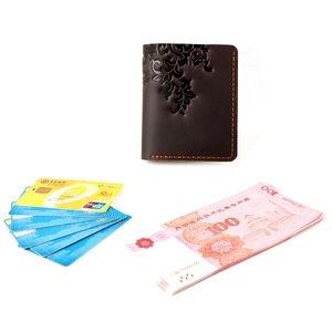 Detail of dark brown leather wallet with embossed floral patterns and hand-stitched seams