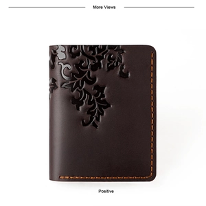Detailed view of dark brown leather wallet with floral embossing and orange hand-stitching