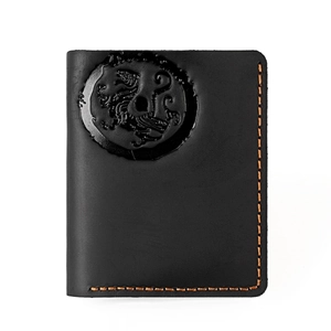 Detail of vintage black leather wallet featuring a beast relief and orange stitching