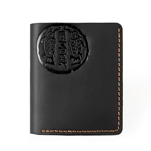 Detail of vintage black crazy horse leather wallet with orange stitching and embossed logo