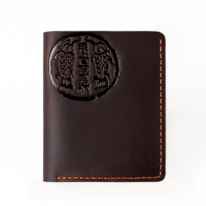 Detail of vintage dark brown crazy horse leather card holder with orange hand-stitched edges