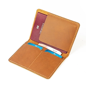 Dettaglio del porta passaporto in pelle marrone vintage con fessure per carte e cuciture a mano