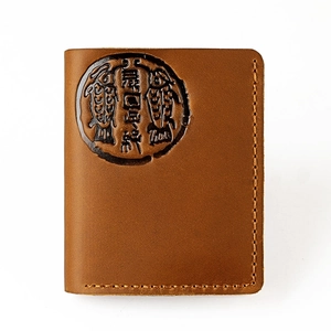 Close-up of vintage brown leather wallet with double fish embossing and manual stitching