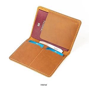 Dettaglio del porta passaporto vintage in pelle marrone con fessure e cuciture a vista