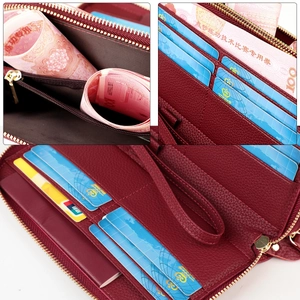 Macro detail of wine red leather wallet featuring RFID blocking slots and gold zippers