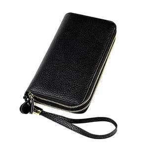 Detail of black pebbled leather texture and gold zippers on RFID travel clutch bag