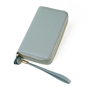 Close-up of greyish blue pebbled leather wallet with double gold zippers and a wrist strap