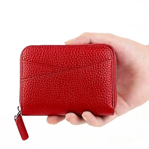 Dettaglio del portafoglio in pelle martellata rossa con zip in metallo e tirante in pelle