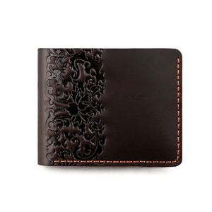 Close-up of deep brown leather wallet with floral embossed pattern and orange stitching