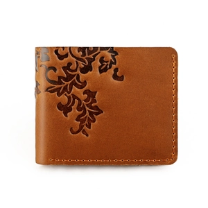 Detail of vintage brown crazy horse leather wallet with embossed leaf and stitching