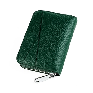 Detail of dark green leather coin purse with lychee texture and silver metal zipper