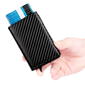 Slim RFID blocking carbon fiber wallet with automatic pop-up card mechanism held by hand