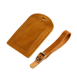 Close-up of vintage crazy horse leather luggage tag with adjustable buckle and stitching