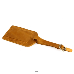 Side view of brown crazy horse leather luggage tag with adjustable strap and stitching