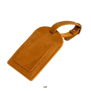 Side view of brown crazy horse leather luggage tag with adjustable buckle strap