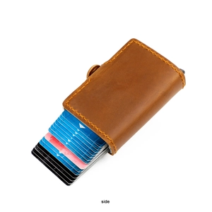 Détail du porte-cartes en cuir de cheval fou montrant l'éjection automatique des cartes