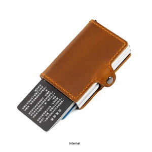Vue détaillée du porte-cartes en cuir marron vintage avec boîtier en aluminium et bouton pression
