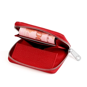 Detail of red pebbled leather coin purse with accordion structure and silver zipper