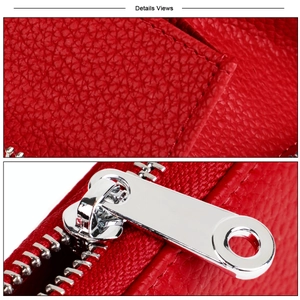 Close-up of red litchi grain leather texture and polished silver metal zipper hardware