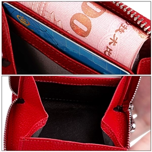 Macro detail of red litchi leather wallet showing double zipper and card slots