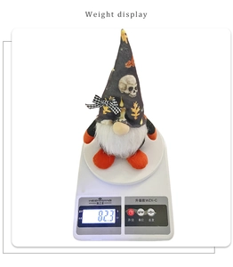 Close-up of Halloween gnome with skull pattern hat being weighed on a white digital scale
