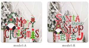Detail of wooden Merry Christmas and Santa Stop Here signs with red and green plaid patterns