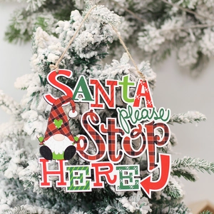 Plaid Christmas wood sign with SANTA please STOP HERE text hanging on a snowy tree