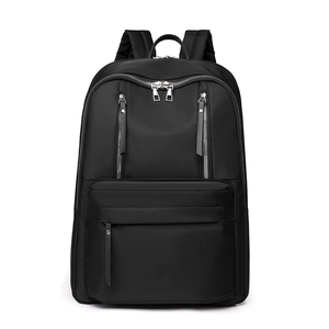 Detail of black waterproof nylon backpack featuring dual vertical silver zippers on front