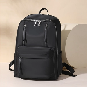 Detail view of water-resistant black nylon backpack with multi-zipper compartments