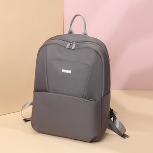 Detail view of water-resistant gray nylon backpack with silver zippers and side pockets