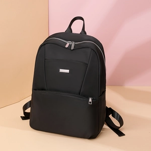 Detail of black nylon backpack featuring smooth texture and durable metal zipper hardware