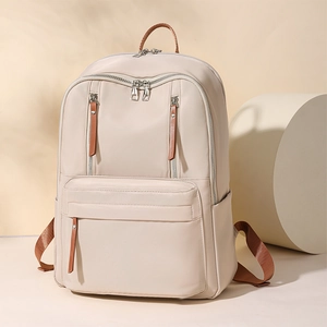 Detail of cream beige nylon backpack with double zippers and brown leather pulls